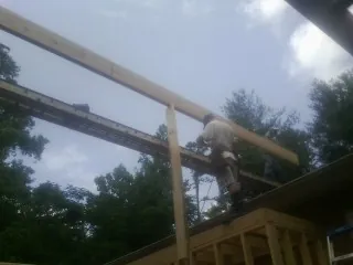 Carpenter setting a ridge beam over a new addition frame — Ice Dam Removal by Roofing Brothers in Reva