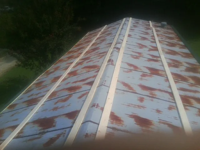 Rusted metal roof panels with new wood purlins before replacement — Storm Damage Roof Repair in Reva by Roofing Brothers